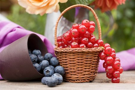 Blueberries in beaker and redcurrants in basket on table Foto de stock - Sin royalties Premium, Código: 659-01858333