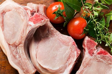 Raw pork chops, fresh herbs and tomatoes Fotografie stock - Premium Royalty-Free, Codice: 659-01858477