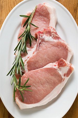 Raw pork chops with rosemary Fotografie stock - Premium Royalty-Free, Codice: 659-01858495