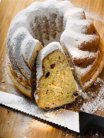 Gugelhupf with icing sugar, partly sliced Stock Photo - Premium Royalty-Free, Code: 659-01858616