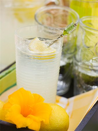 simsearch:659-03531671,k - Glass of lemonade, lemon and flower on tray Foto de stock - Sin royalties Premium, Código: 659-01858660