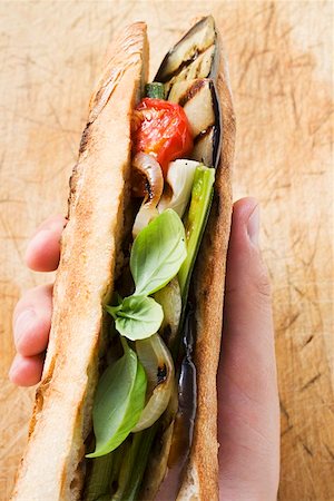 simsearch:659-01860961,k - Hand holding grilled vegetables and basil in baguette Foto de stock - Royalty Free Premium, Número: 659-01858705