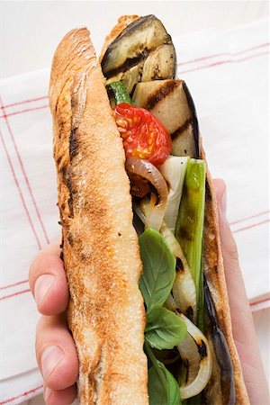 simsearch:659-01864099,k - Hand holding grilled vegetables and basil in baguette Foto de stock - Sin royalties Premium, Código: 659-01858707