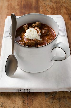 Goulash soup with sour cream in cup, with spoon Stock Photo - Premium Royalty-Free, Code: 659-01859165