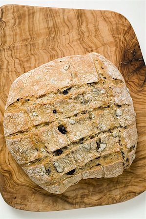 simsearch:659-01866647,k - Crusty olive bread on chopping board (overhead view) Foto de stock - Royalty Free Premium, Número: 659-01859422