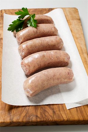 raw sausage - Several salsicce on paper on chopping board Stock Photo - Premium Royalty-Free, Code: 659-01859475