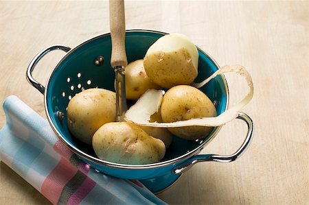 Potatoes, one half-peeled, in colander Foto de stock - Sin royalties Premium, Código: 659-01859485