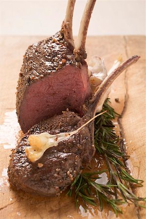 Rack of venison, partly carved, with garlic and rosemary Stock Photo - Premium Royalty-Free, Code: 659-01859854