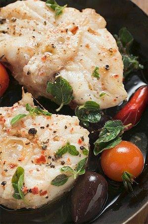 Monkfish cutlets with cherry tomatoes & olives in frying pan Stock Photo - Premium Royalty-Free, Code: 659-01859862