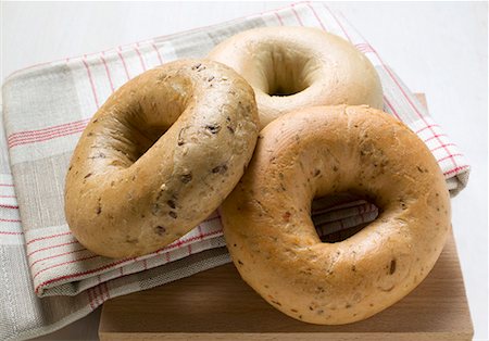 Three different bagels on tea towel Stock Photo - Premium Royalty-Free, Code: 659-01859905