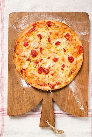 simsearch:659-01859933,k - Toute pizza Margherita sur planche à découper Photographie de stock - Premium Libres de Droits, Code: 659-01859923