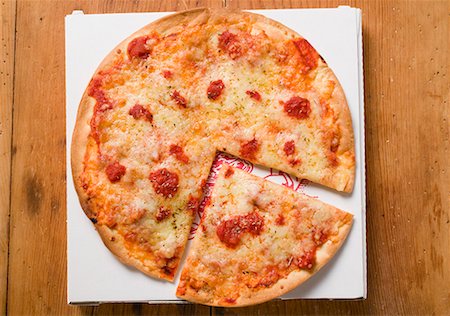 simsearch:659-01862906,k - Pizza Margherita, a slice cut, on pizza box Foto de stock - Sin royalties Premium, Código: 659-01859930