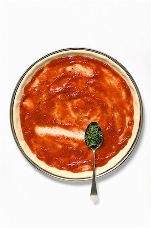 Pizza base with tomato sauce and spoonful of oregano Stock Photo - Premium Royalty-Free, Code: 659-01859949