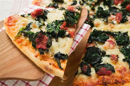 pizza piece - Spinach, tomato and cheese pizza with slice on server Foto de stock - Sin royalties Premium, Código: 659-01859940