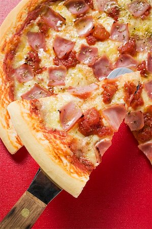 pizza piece - Ham, cheese and tomato pizza with slice on server Foto de stock - Sin royalties Premium, Código: 659-01859974