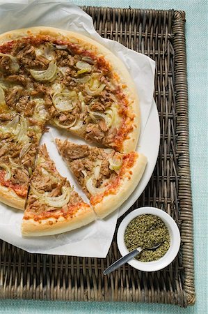 Tuna and onion pizza, partly sliced, oregano beside it Foto de stock - Sin royalties Premium, Código: 659-01859987