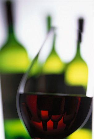 simsearch:659-06155174,k - Verre de vin rouge en face de bouteilles de vin Photographie de stock - Premium Libres de Droits, Code: 659-01850062