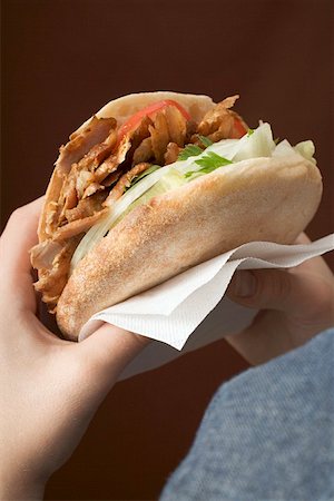 Hands holding a döner kebab Stock Photo - Premium Royalty-Free, Code: 659-01850106