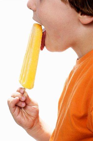 Boy enjoying an orange ice lolly Foto de stock - Sin royalties Premium, Código: 659-01850909