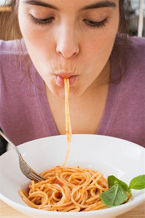simsearch:659-01855701,k - Young woman eating spaghetti with tomato sauce Stock Photo - Premium Royalty-Free, Code: 659-01851197