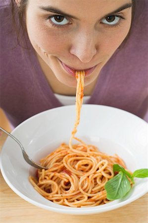 simsearch:659-01855701,k - Young woman eating spaghetti with tomato sauce Stock Photo - Premium Royalty-Free, Code: 659-01851198