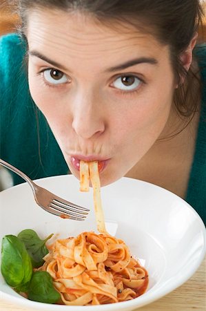 simsearch:659-01855701,k - Young woman eating ribbon pasta with tomato sauce Stock Photo - Premium Royalty-Free, Code: 659-01851199