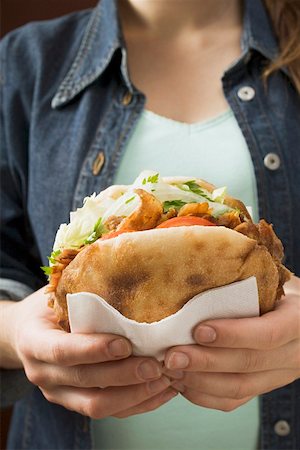 simsearch:659-01862723,k - Jeune femme tenant un döner kebab dans ses mains Photographie de stock - Premium Libres de Droits, Code: 659-01851201