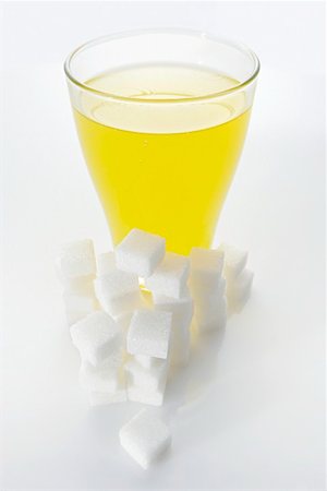 sugar cube on white - Orangeade & sugar cubes (picture symbolising high sugar content) Stock Photo - Premium Royalty-Free, Code: 659-01851476