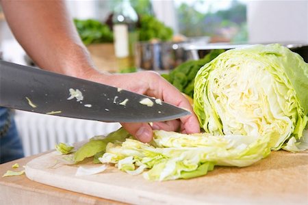 Cutting iceberg lettuce into bite sized pieces Stock Photo - Premium Royalty-Free, Code: 659-01851540