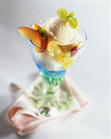 sundae - Vanilla ice cream with fruit & lemon balm in a sundae glass Foto de stock - Sin royalties Premium, Código: 659-01851696