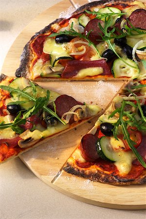 pizza piece - Salami and vegetable pizza with fresh rocket, a piece cut Foto de stock - Sin royalties Premium, Código: 659-01851860