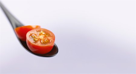 simsearch:659-03521206,k - Tomate cocktail coupe ouverte sur une cuillère noire Photographie de stock - Premium Libres de Droits, Code: 659-01852135