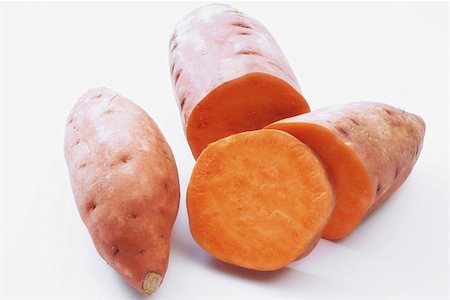 simsearch:659-01846978,k - Two sweet potatoes, one partly sliced Foto de stock - Royalty Free Premium, Número: 659-01852339