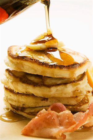sciroppo - Pouring maple syrup over pancakes butter and bacon Fotografie stock - Premium Royalty-Free, Codice: 659-01852490