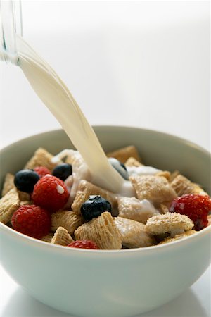 Pouring milk over shredded wheat cereal Stock Photo - Premium Royalty-Free, Code: 659-01852641