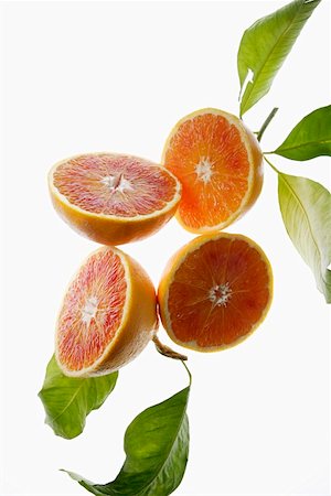 Halved blood oranges, variety 'Tarocco', with leaves Stock Photo - Premium Royalty-Free, Code: 659-01852703