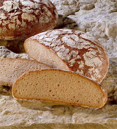 stone slab - One whole loaf of bread and one with slices cut Stock Photo - Premium Royalty-Free, Code: 659-01852780