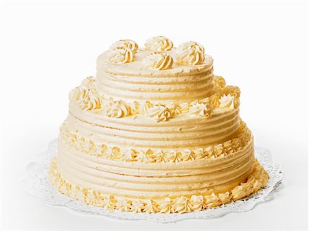 A three-tiered cream cake on white background Stock Photo - Premium Royalty-Free, Code: 659-01853014