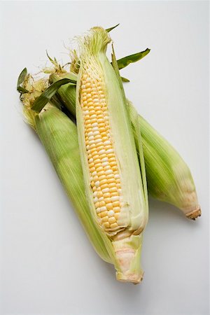 Three corn cobs with husks Stock Photo - Premium Royalty-Free, Code: 659-01853361