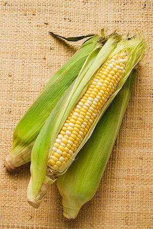 Three corn cobs with husks Stock Photo - Premium Royalty-Free, Code: 659-01853376