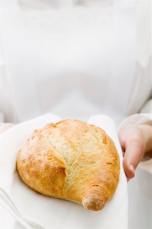 Chambermaid serving bread on fabric napkin Stock Photo - Premium Royalty-Free, Code: 659-01864014