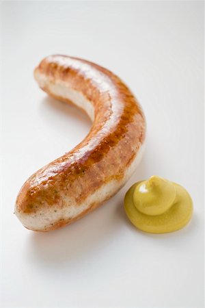 fried sausage recipe - Sausage (bratwurst) with mustard on white background Stock Photo - Premium Royalty-Free, Code: 659-01864038