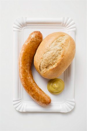 Sausage (bratwurst) with mustard & bread roll on paper plate Stock Photo - Premium Royalty-Free, Code: 659-01864039