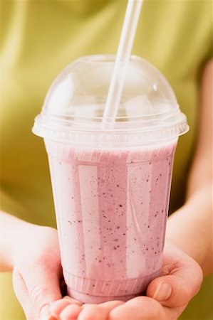 Hands holding blueberry smoothie in plastic beaker Stock Photo - Premium Royalty-Free, Code: 659-01864033