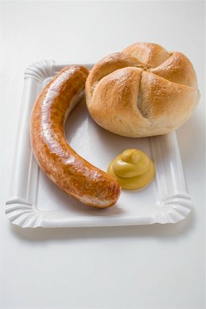 Sausage (bratwurst) with mustard & bread roll on paper plate Stock Photo - Premium Royalty-Free, Code: 659-01864040