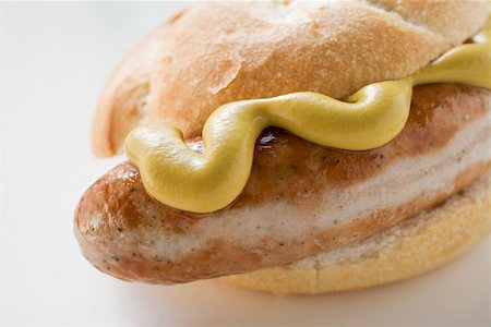 Sausage (bratwurst) with mustard in bread roll Foto de stock - Sin royalties Premium, Código: 659-01864042