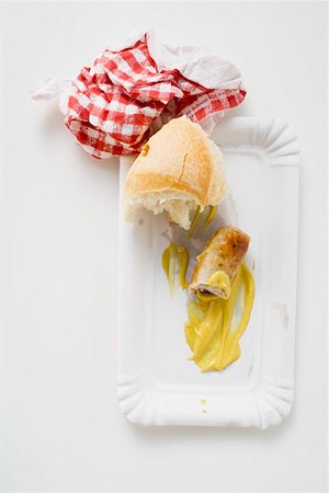 simsearch:659-01864043,k - Remains of sausage with mustard & bread roll on paper plate Foto de stock - Sin royalties Premium, Código: 659-01864059