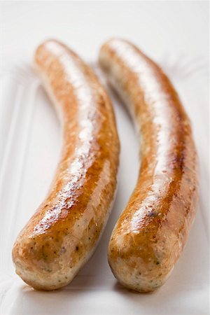 salsichão de porco - Two sausages (bratwursts) on paper plate Foto de stock - Royalty Free Premium, Número: 659-01864051