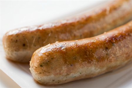 salsichão de porco - Two sausages (bratwursts) on paper plate (close-up) Foto de stock - Royalty Free Premium, Número: 659-01864052