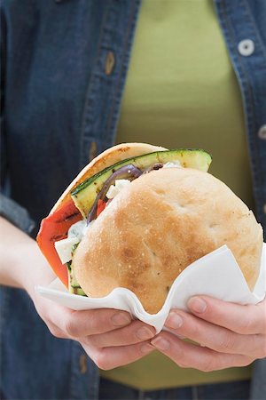 Woman holding toasted roll filled with grilled vegetables Stock Photo - Premium Royalty-Free, Code: 659-01864100